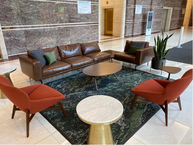 Lobby lounge at Three Logan Square with leather sofa and orange accent chairs