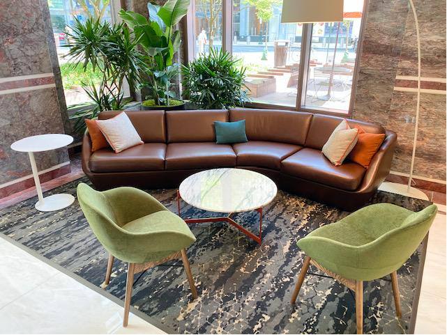 Three Logan Square lounge with curved leather sofa, green chairs and marble tables